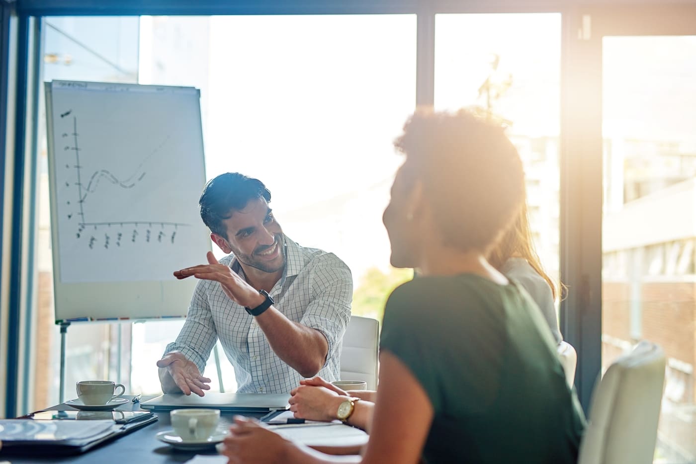 Two people having a discussion in front of a white board in an office.