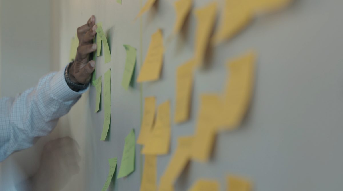 Clustering sticky notes on a wall during a strategic planning session